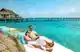 Couple enjoying a serene moment on a wooden deck with ocean view, best restaurants in Maldives.