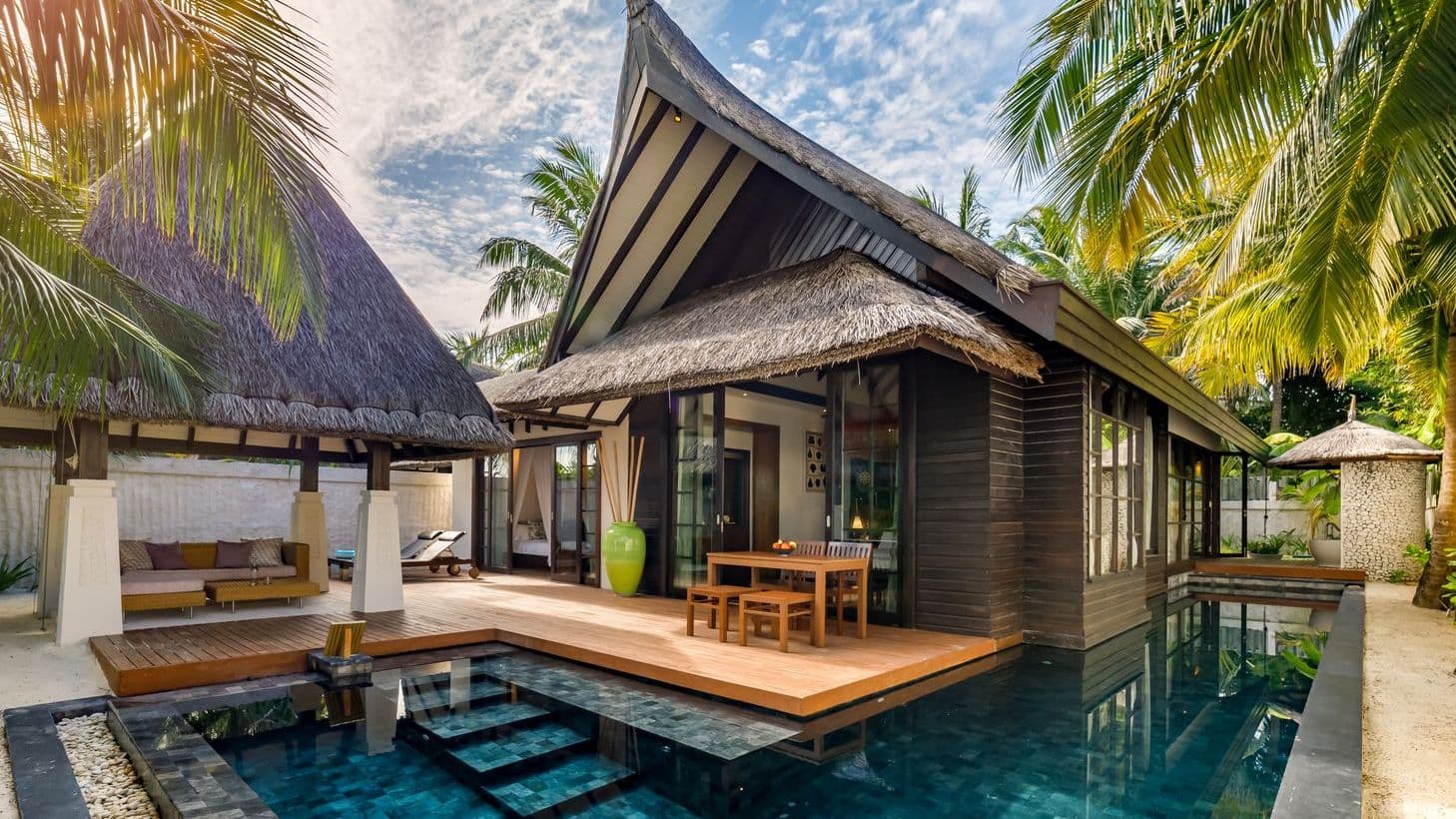 Earth Pool Pavilion 2 Bedroom Suite aerial view of tropical beach with palm trees and clear waters.