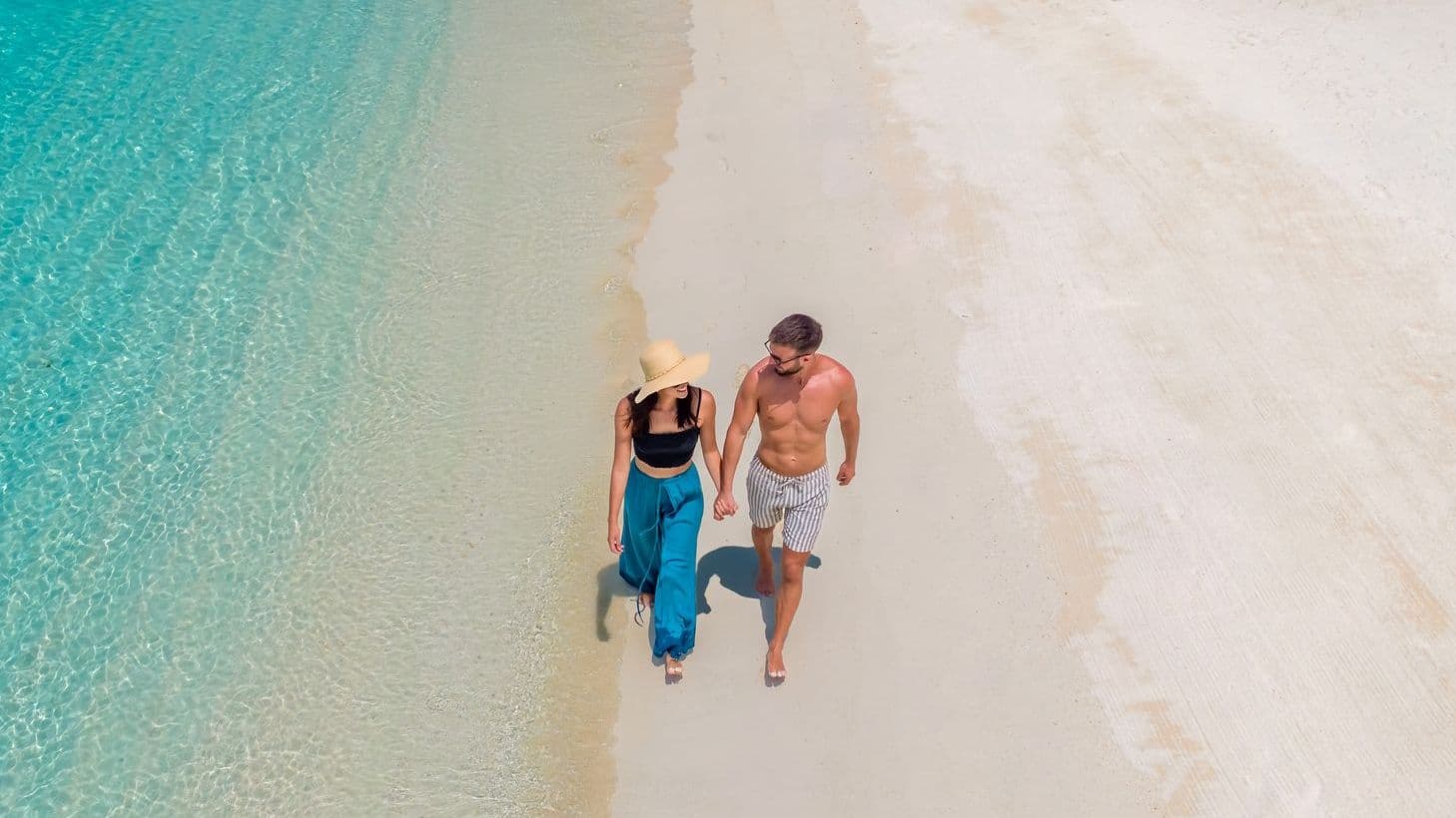 Cozy bedroom with a bed, TV, and wooden ceiling in luxury villas in Maldives.