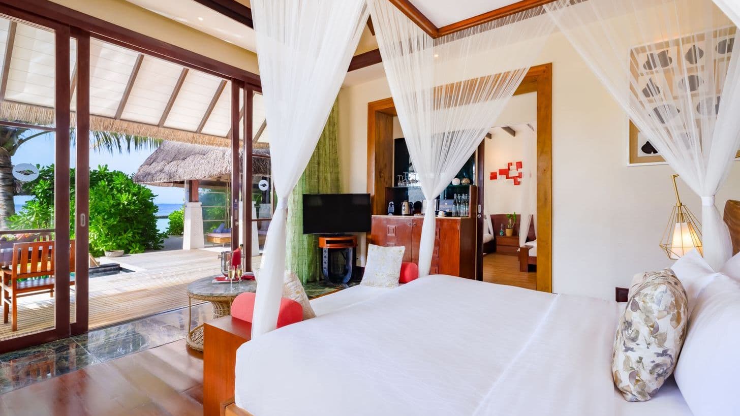 Earth Pool Pavilion 2 Bedroom Suite aerial view of tropical beach with palm trees and clear waters.