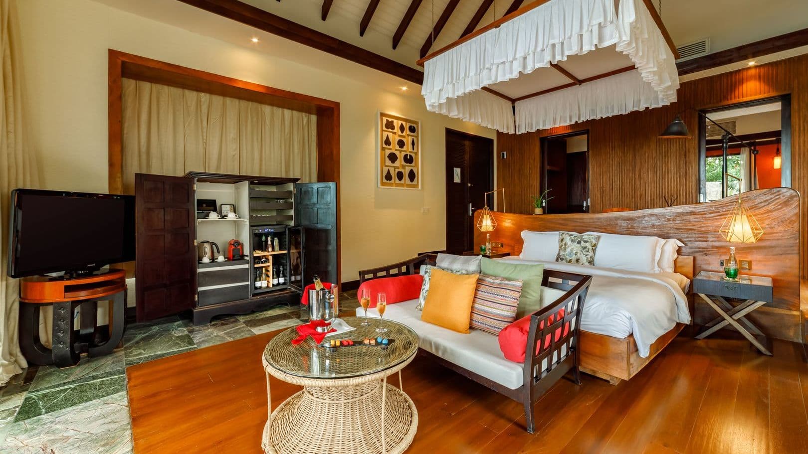 Serene resort with a sparkling pool, thatched-roof villas, and lush greenery in Maldives.