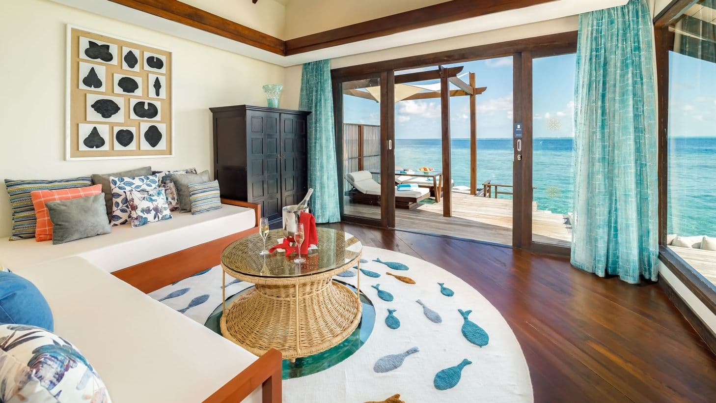 Luxury villas in Maldives with Ocean Pool Suite, tranquil pool and thatched huts under blue sky.