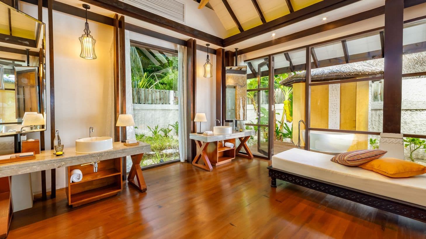 Serene resort with a sparkling pool, thatched-roof villas, and lush greenery in Maldives.
