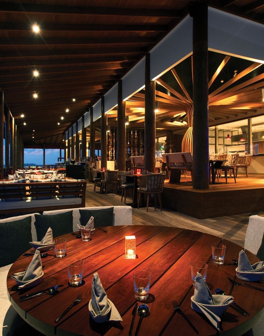 Beachside restaurant with tables set for dining, ocean view, offering authentic Chinese cuisine.